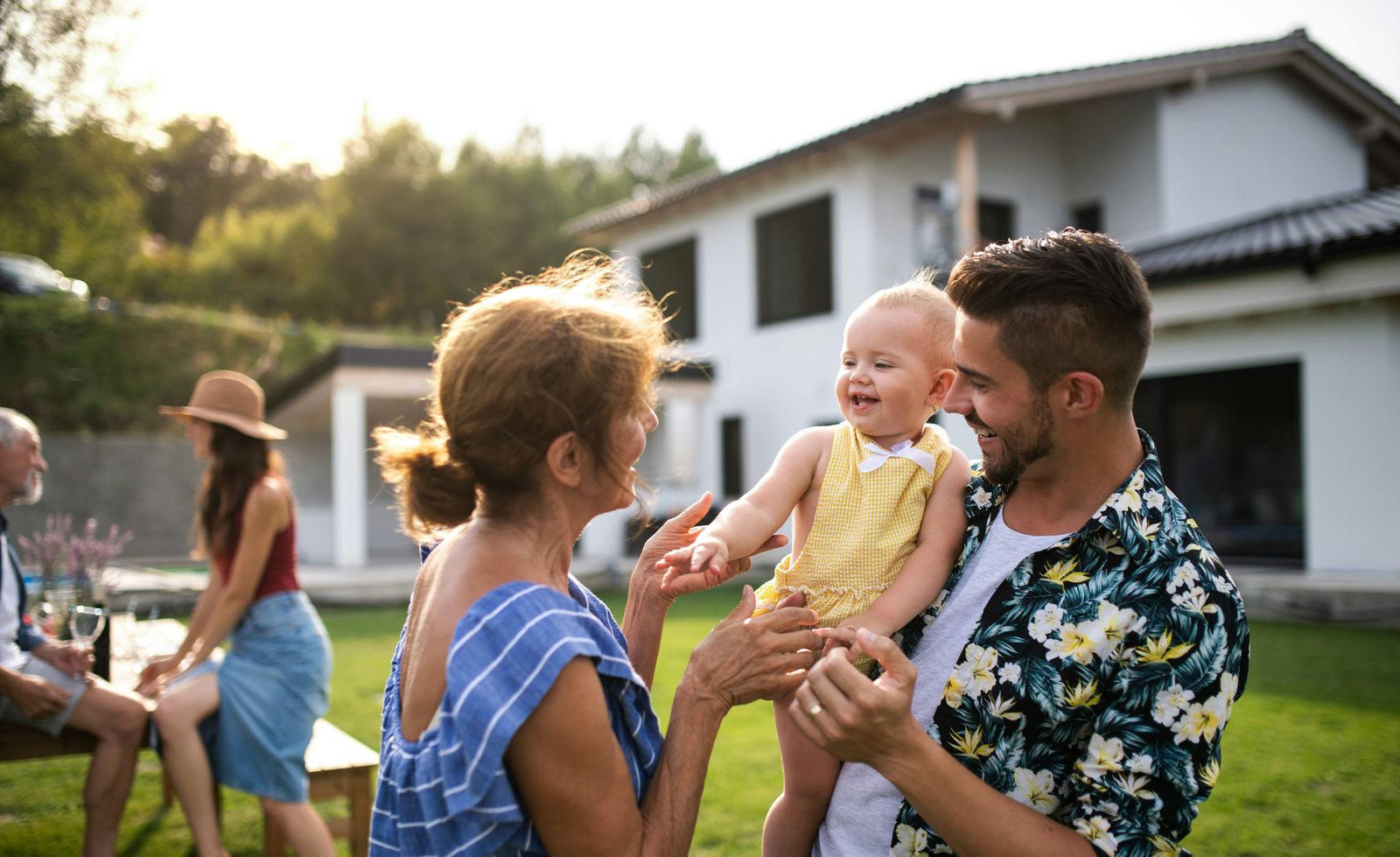 Familie im Garten vor dem eigenen Haus